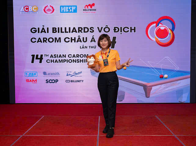 Vận động viên billiards vào thế đánh trên bàn carom thumbnail 3